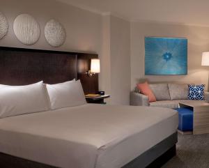 a hotel room with a large bed and a couch at Hilton Orlando Buena Vista Palace - Disney Springs Area in Orlando