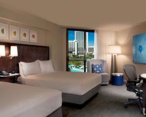 a hotel room with two beds and a window at Hilton Orlando Buena Vista Palace - Disney Springs Area in Orlando