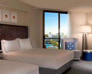 a hotel room with a bed and a chair and a window at Hilton Orlando Buena Vista Palace - Disney Springs Area in Orlando +37 photos