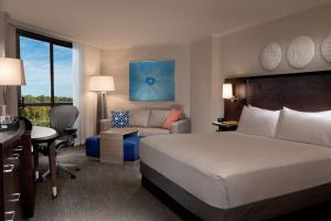 a hotel room with a bed and a chair and a desk at Hilton Orlando Buena Vista Palace - Disney Springs Area in Orlando +28 photos