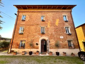 duży ceglany budynek z drzwiami z przodu w obiekcie Magical villa, breathtaking views, large private garden and olive grove - in a cool village on the Umbria Tuscany Border w mieście Gioiella