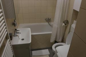 a bathroom with a tub and a sink and a toilet at CENTRUM with private parking in Virovitica +24 photos