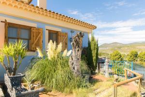 una casa con un albero nel cortile anteriore di Casa Poniente - Casa Rural Los Cuatro Vientos a Moratalla
