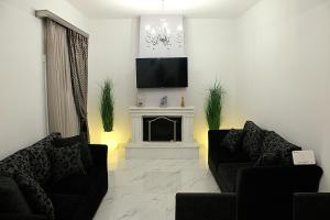 a living room with two chairs and a fireplace at BLACK & WHITE SeaSide House Kalamia in Korinthos