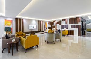 a lobby with yellow chairs and tables in a building at Alqasr Al masyaf in Khamis Mushayt +20 photos