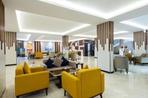 a lobby with yellow chairs and a table at Alqasr Al masyaf in Khamis Mushayt