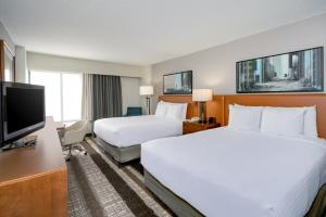 a hotel room with two beds and a flat screen tv at Crowne Plaza Dulles Airport, an IHG Hotel in Herndon
