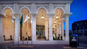 a large building with flags in front of it at Hilton Hotel & Convention Jabal Omar Makkah in Mecca