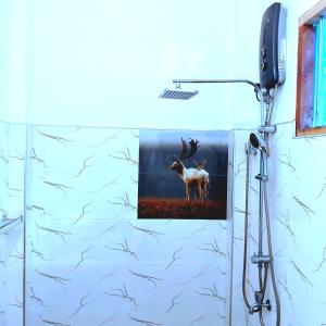 a painting of a deer on a wall in a bathroom at gramatic dream cottage in Udawalawe