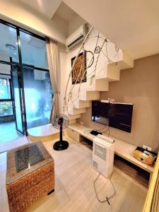 ein Wohnzimmer mit einer Treppe und einem TV in der Unterkunft Egypt泡湯宿 in Jiaoxi