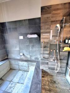 ein großes Bad mit einer Dusche und einer Badewanne in der Unterkunft Egypt泡湯宿 in Jiaoxi