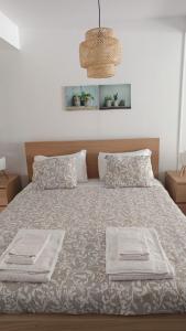 a bedroom with a bed with two towels on it at WATERS HOUSE STUDIO in Peniche