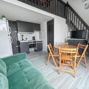 a living room with a table and chairs and a kitchen at T2 lumineux & paisible à quelques pas du sable fin in Le Barcarès