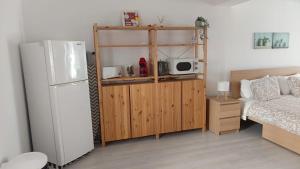 a small room with a refrigerator and a bed at WATERS HOUSE STUDIO in Peniche +14 photos