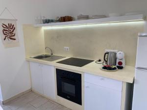 a small kitchen with a sink and a stove at Djadsal Moradias - By Bobbywashere in Santa Maria