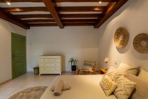 une chambre avec un grand lit et un plafond en bois dans l'établissement Le Baron Perché, à Saint-Cyprien