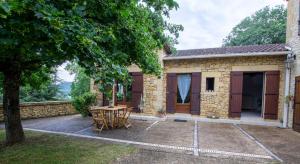 un patio avec une table et des chaises devant une maison dans l'établissement Le Baron Perché, à Saint-Cyprien