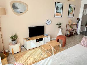 a living room with a flat screen tv on a wall at Appartement Cosy avec Balcon in Parentis-en-Born