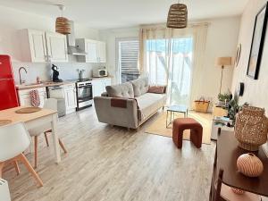 ein Wohnzimmer mit Sofa und Tisch in der Unterkunft Appartement Cosy avec Balcon in Parentis-en-Born