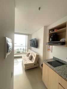 a living room with a couch and a kitchen at Apartamento de lujo con Vista al Mar in Santa Marta