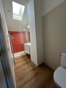 a bathroom with a toilet and a sink and a window at Loft Atelier d'Artiste Mussidan in Mussidan