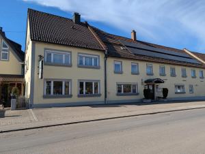 a large white building on the side of a street at Hotel-Gasthof Zur Rose in Weißenhorn +21 photos