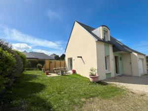 a white house with a yard with a patio at Maison des Dunes in Plougoulm