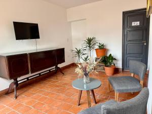a living room with a flat screen tv and a table at Clivias Hostel in Salta