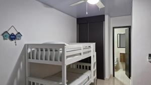 NancitoADVENTURE House的卧室配有白色婴儿床和吊扇