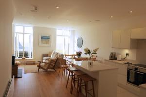 林茅斯Harbour Tide, Inviting 3 BR Apt, Large Terrace and Sea View, Parking的配有桌椅的厨房和客厅 更多37张照片