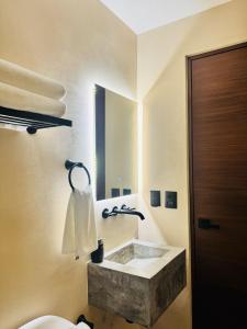a bathroom with a stone sink and a mirror at Kauil Tulum in Tulum