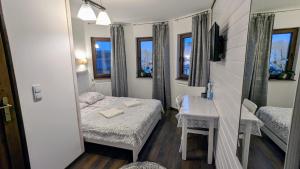 a small room with a bed and a mirror at Sosnowa Polana Białowieża in Białowieża