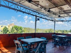 a patio with tables and chairs on a deck at Kauil Tulum in Tulum