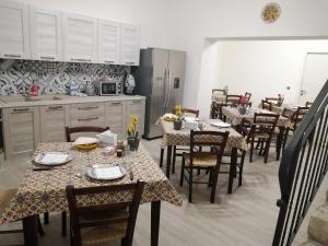 a kitchen with tables and chairs and a kitchen with white cabinets at Bed And Breakfast Polizzi House in Petralia Sottana