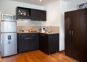 a kitchen with black cabinets and a stainless steel refrigerator at Jazz Apartments Luxury Suites in Bogotá