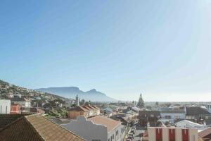 a city with houses and mountains in the background at 1 Bedroom Muizenberg Beach Apartment with Pool and Mountain Views in Muizenberg