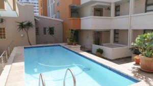 a large swimming pool on top of a building at 1 Bedroom Muizenberg Beach Apartment with Pool and Mountain Views in Muizenberg