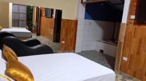 a room with two beds and a flat screen tv at La puzanguita suite in Tarapoto