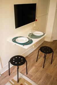 una mesa con dos sillas y dos platos en ella en Saint Germain de Près tout équipé - Emplacement exceptionnel au Coeur de Paris, en París