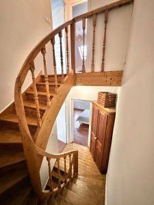 eine hölzerne Wendeltreppe in einem Haus mit einem Treppenhaus in der Unterkunft Madeleine - Maison élégante tout confort au cœur de Berck-Plage in Berck-sur-Mer
