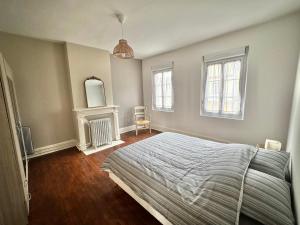 ein Schlafzimmer mit einem großen Bett und zwei Fenstern in der Unterkunft Madeleine - Maison élégante tout confort au cœur de Berck-Plage in Berck-sur-Mer + 23 Fotos