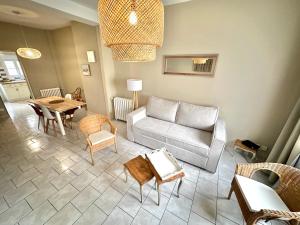 ein Wohnzimmer mit Sofa und Tisch in der Unterkunft Madeleine - Maison élégante tout confort au cœur de Berck-Plage in Berck-sur-Mer