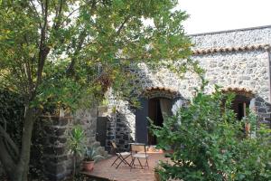 a stone house with a patio and trees at B&B Villa Loriana in Milo