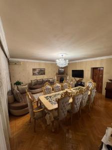 a dining room with a table and chairs and a couch at Sabail APART in Baku