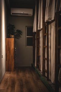 a room with wooden floors and curtains and a door at 旅兜- house in Lanyu +9 photos