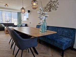 a living room with a blue couch and a wooden table at Modern spacious holiday home within walking distance of the North Sea beach in De Koog in De Koog