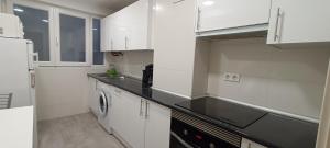 桑坦德Casa Laura的厨房配有白色橱柜和一台洗衣机