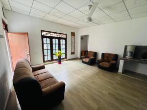 a living room with a couch and two chairs at New Pearl Guest Inn in Badulla