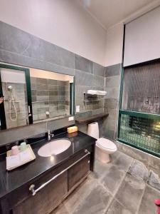 ein Badezimmer mit Waschbecken und Toilette in der Unterkunft Cafe溫泉屋 in Jiaoxi