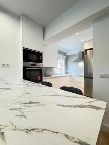 Una cocina blanca con una gran encimera de mármol. en Nohe, en Cuenca